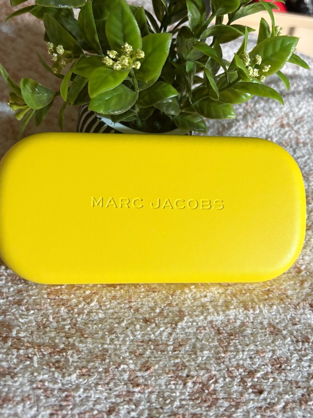 Marc Jacobs Yellow Hard Shell Sunglasses Case with sunglasses inside.